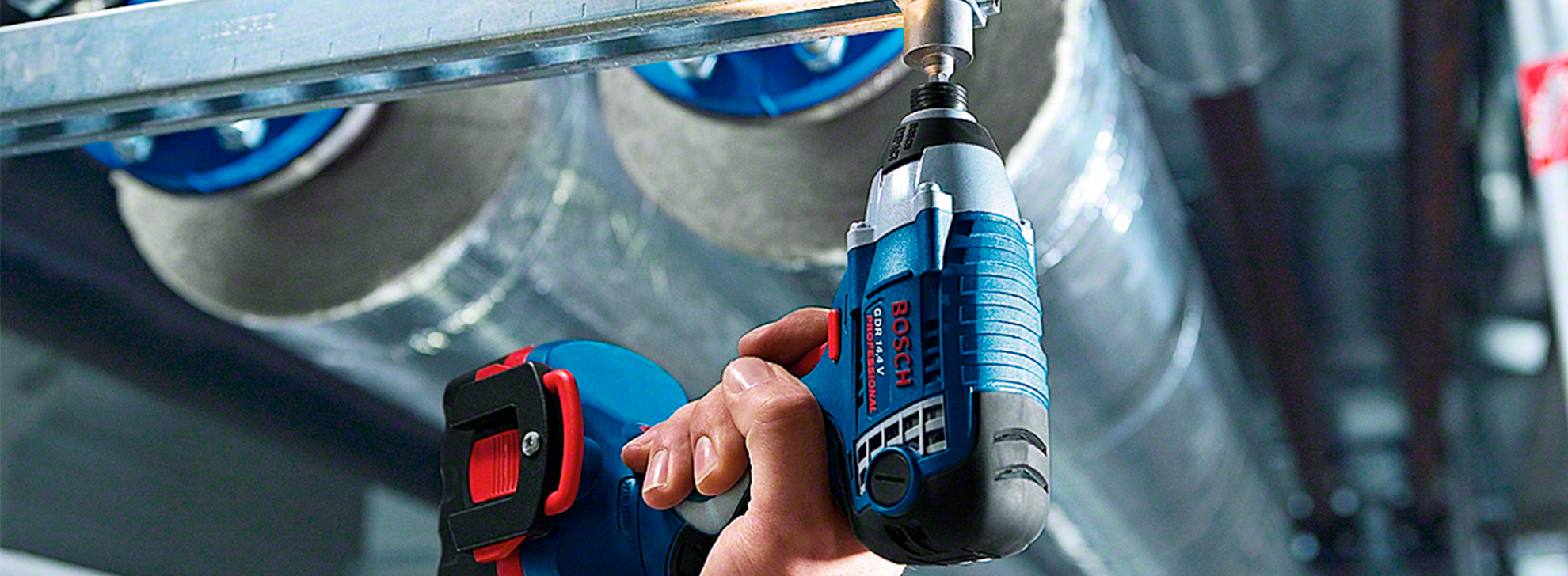 Uma furadeira Bosch Professional é usada em um tubo de metal em uma oficina.