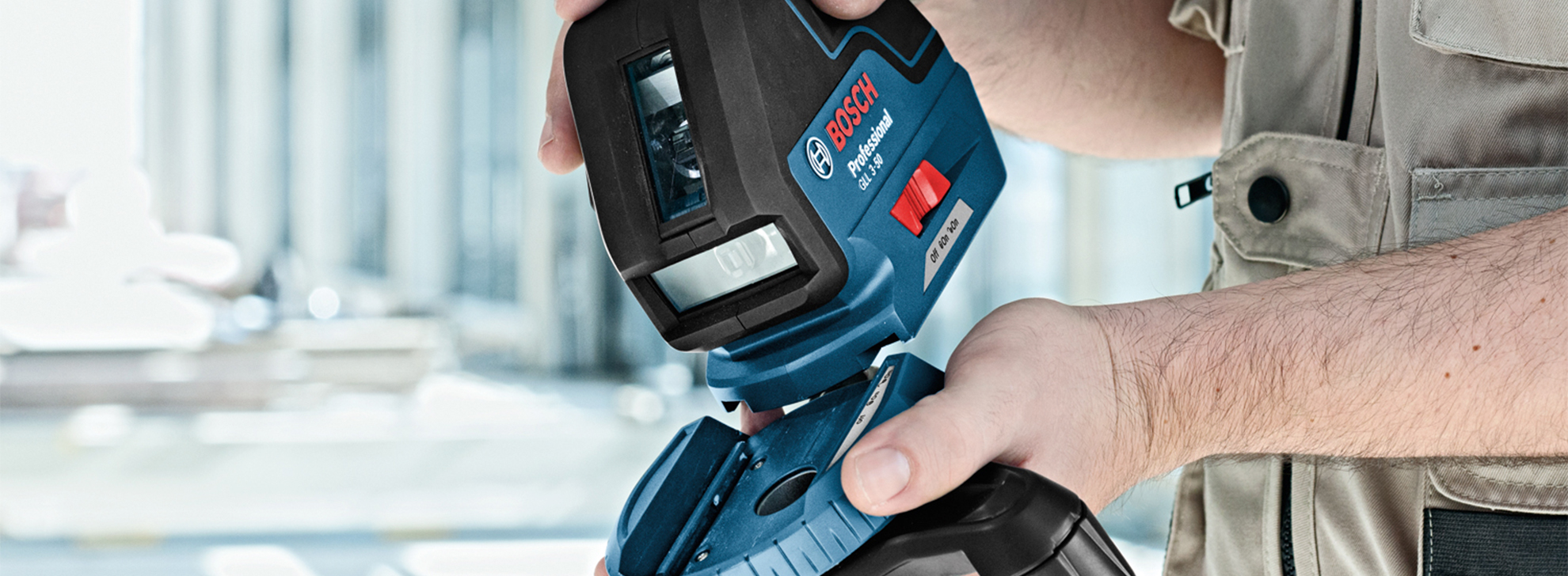 Um nível a laser Bosch Professional segurado por uma pessoa com uma camisa.