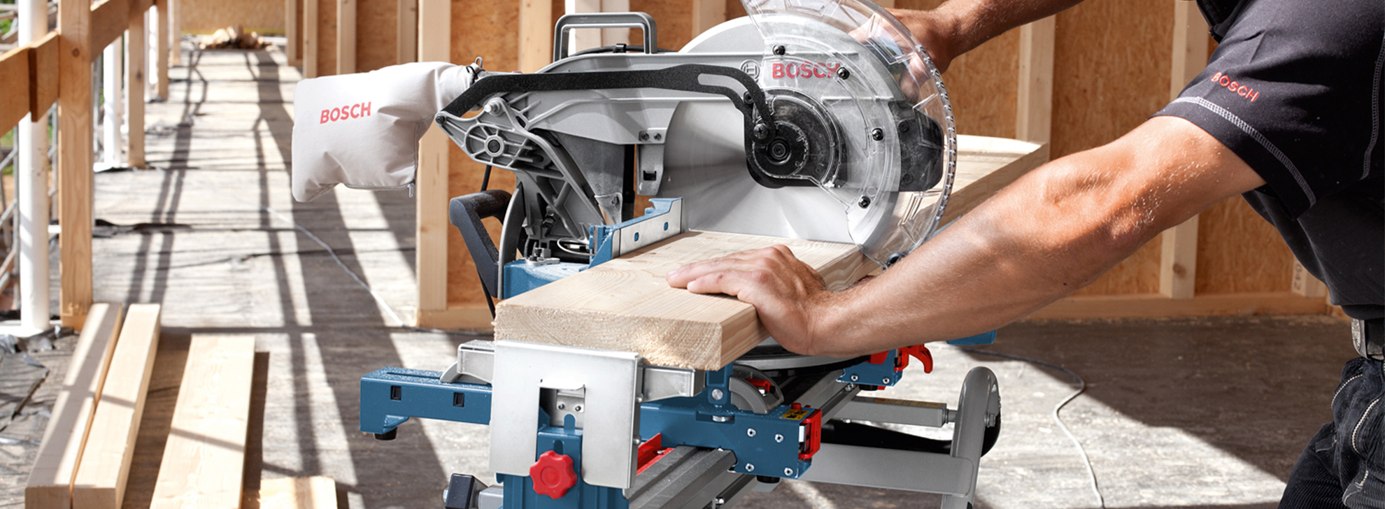 Uma serra de esquadria Bosch Professional corta uma tábua de madeira em um canteiro de obras.