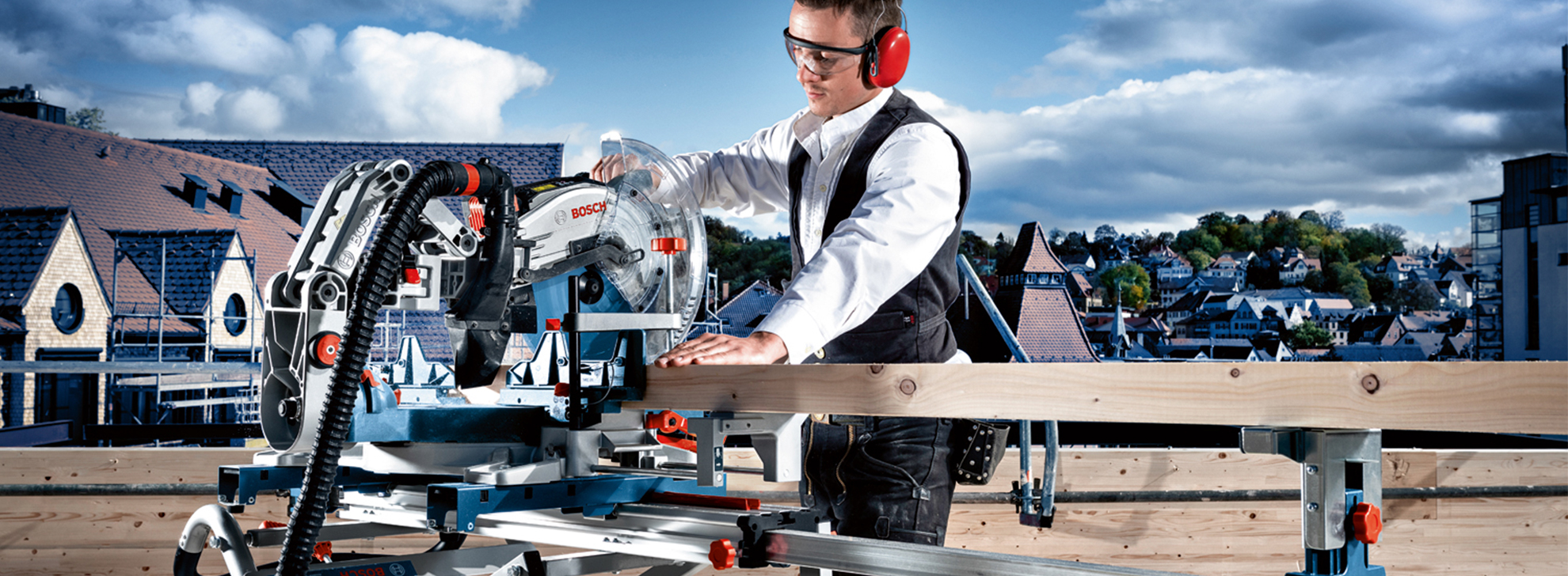 Um homem com equipamento de segurança opera uma serra de esquadria Bosch Professional em madeira.