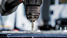 Uma furadeira Bosch Professional está perfurando uma superfície metálica.