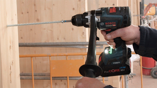 Uma furadeira Bosch Professional sendo usada em madeira, com um parafuso visível.