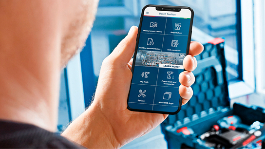 Uma pessoa segura um smartphone exibindo a interface do aplicativo Bosch Toolbox.