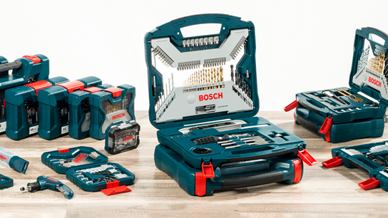 Kits de ferramentas Bosch Professional dispostos sobre uma superfície de madeira, apresentando brocas e pontas.