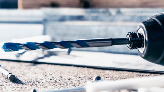 Uma broca Bosch Professional com fita azul sobre uma superfície de trabalho.