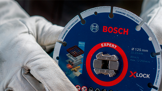 Uma lâmina de diamante Bosch Expert X-LOCK segurada em mãos com luvas.
