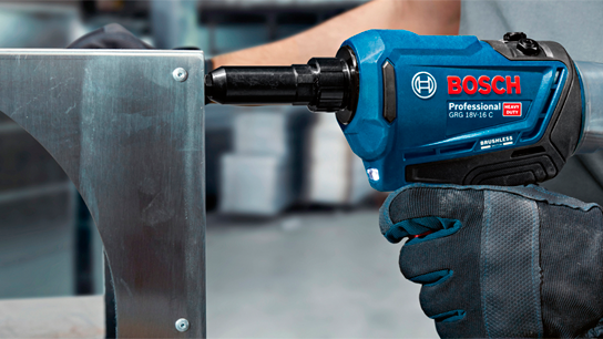 Uma furadeira sem fio Bosch Professional azul está apertando uma peça de metal.