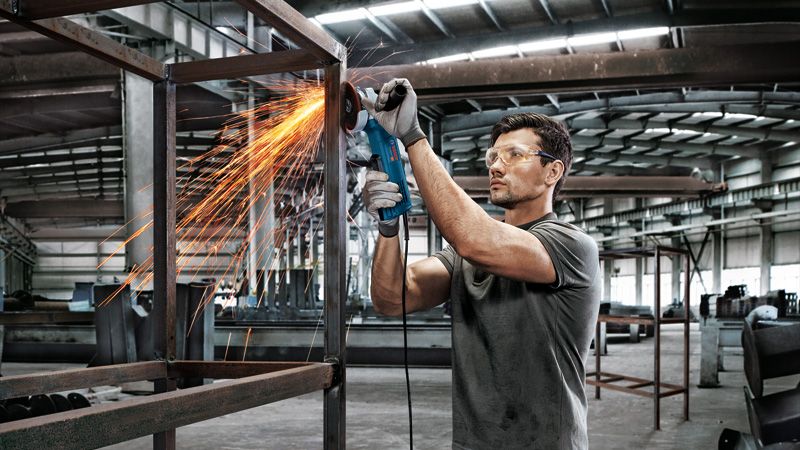 Homem triturando estrutura de metal.