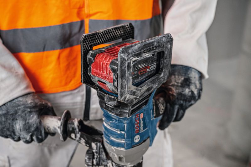 Uma pessoa usando equipamento de segurança opera um mecanismo de agitação sem fio.