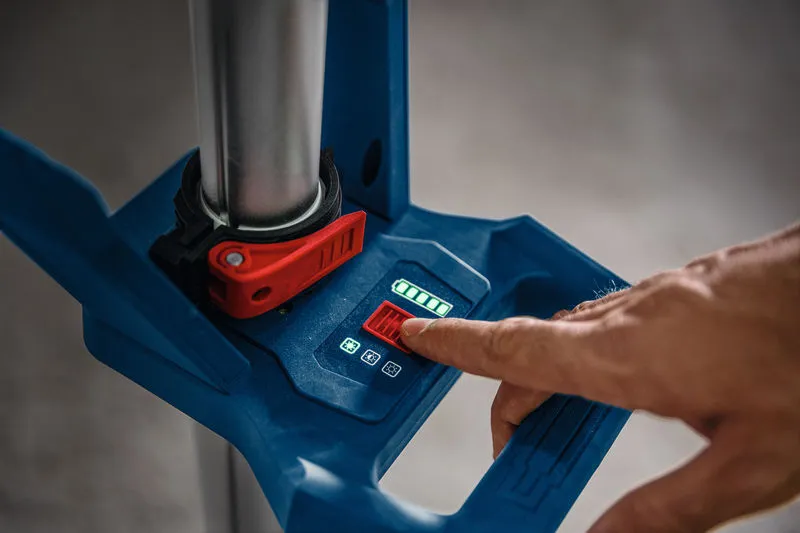 Uma pessoa ajusta uma luminária de obra sem fio usando um painel de controle digital.