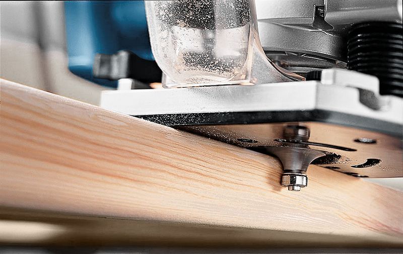 Fresadora de madera dando forma al borde de una tabla de madera.