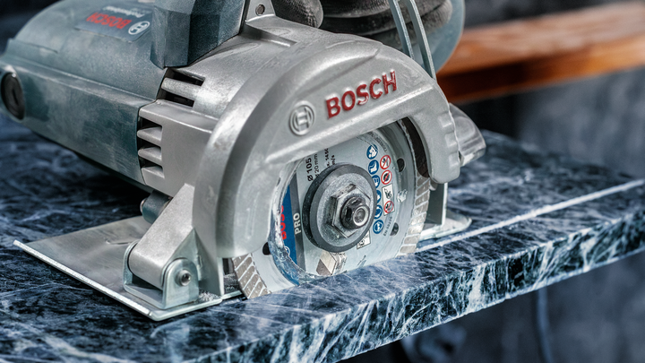 Sierra circular cortando una losa de piedra pulida.