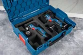 Estuche de transporte azul con pulidora y dos herramientas eléctricas inalámbricas de 12 V aseguradas en espuma.