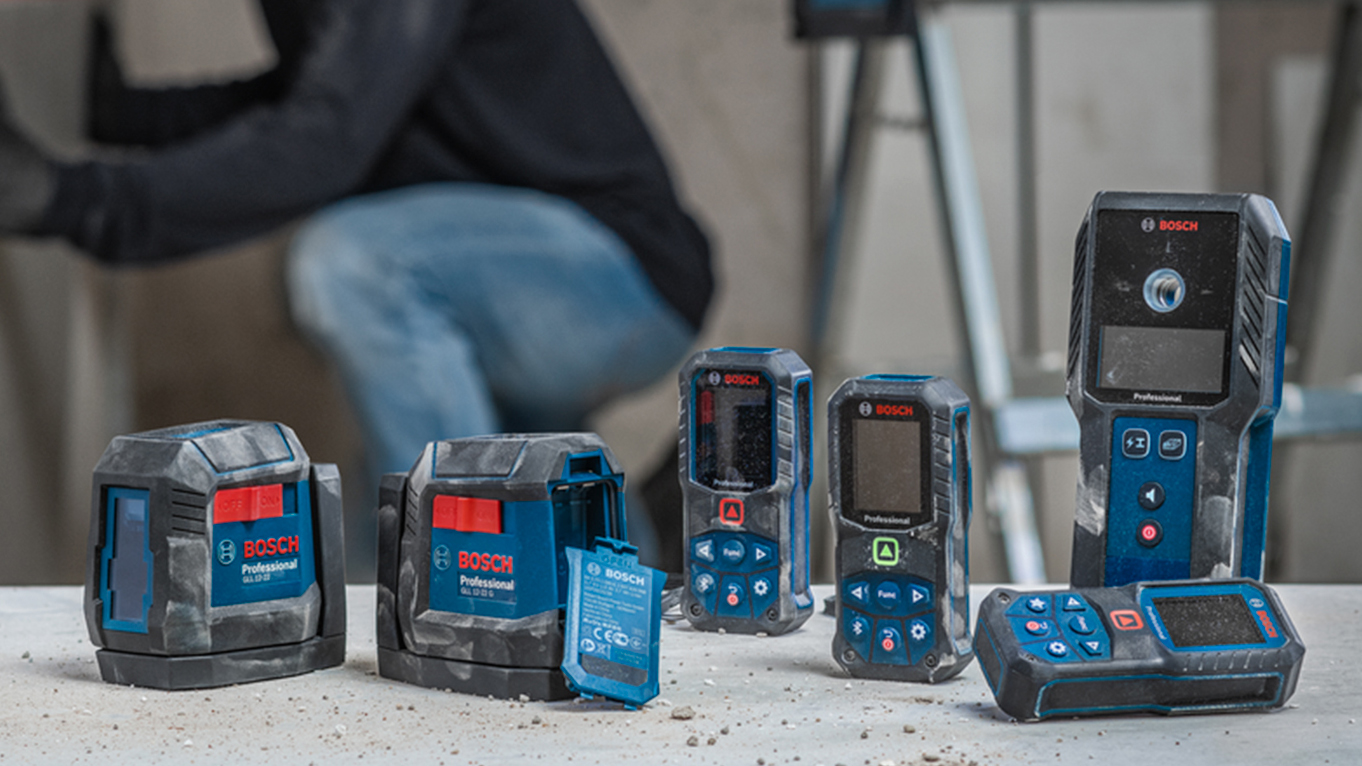 Varios herramientas Bosch Professional en una mesa, con un operario al fondo.