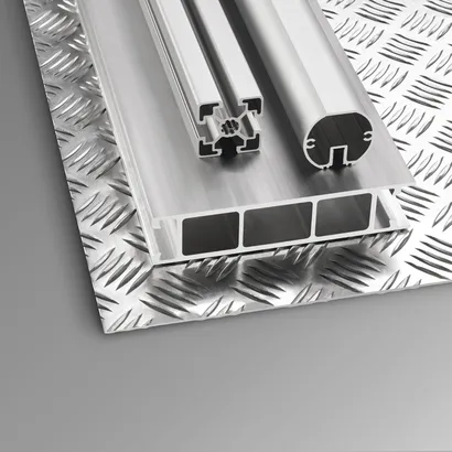 Auf einem strukturierten Metallblech platzierte extrudierte Aluminiumprofile.