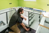 Eine Person installiert Schränke und verwendet dabei ein digitales Neigungsmessgerät auf der Theke.