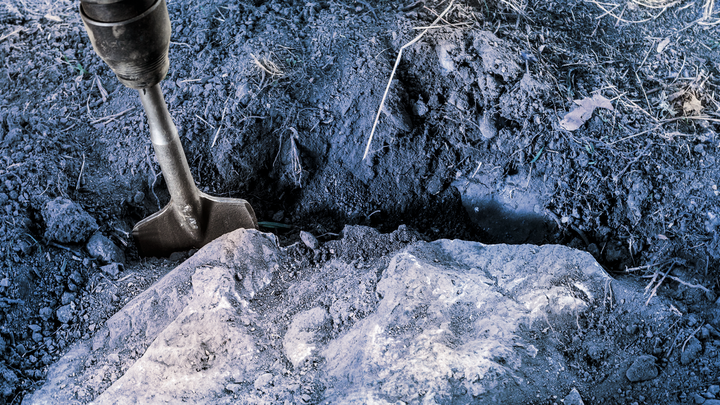 Meißel zum Aufbrechen von hartem Boden und Gestein in einem Graben im Freien.