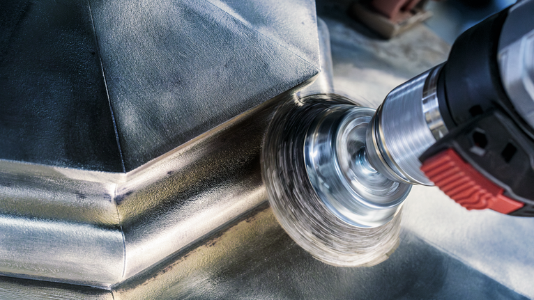 Metallbürstenwerkzeug zum Polieren einer Edelstahloberfläche.