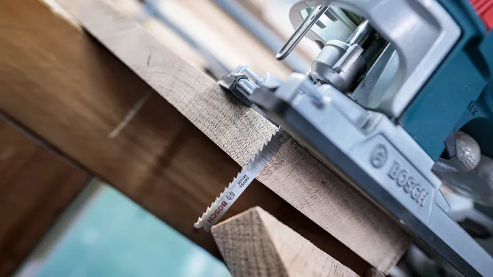 Stichsäge schneidet in einer präzisen geraden Linie durch ein Holzbrett.