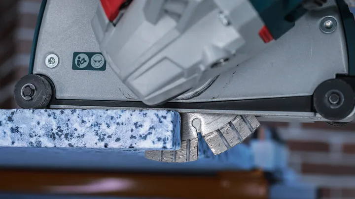 Elektrowerkzeug mit Diamantklinge schneidet durch eine Granitplatte.
