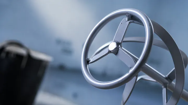 Metallischer Rührpaddelaufsatz für ein Elektrowerkzeug, unscharfer industrieller Hintergrund.