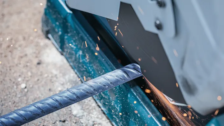 Eine Motorsäge schneidet durch eine Metallbewehrung und erzeugt dabei Funken.