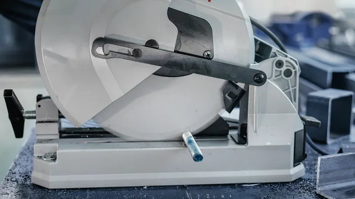 Metallsäge neben mehreren abgewinkelten Stahlstangen positioniert.