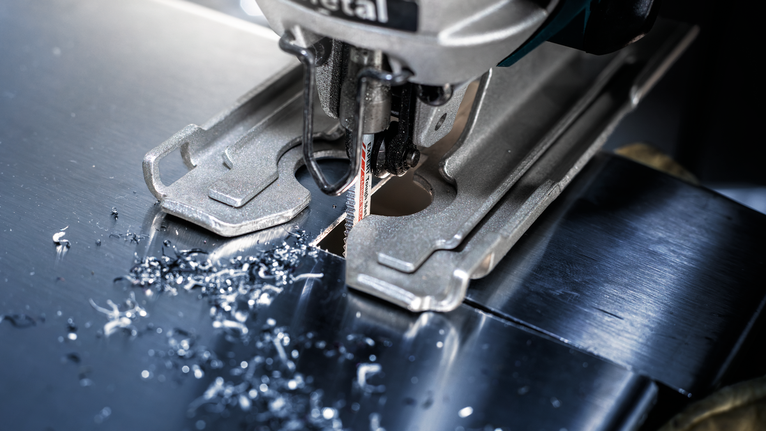 Stichsäge schneidet ein präzises Loch durch ein glänzendes Metallblech.