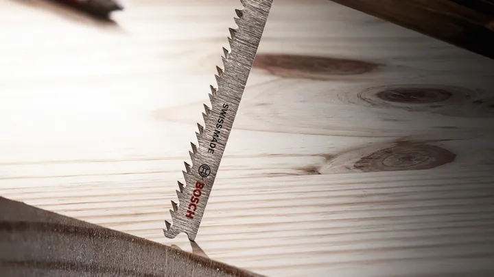 Stichsägeblatt schneidet durch ein Holzbrett.