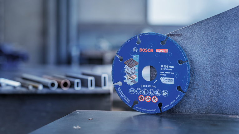 Eine Diamanttrennscheibe lehnt in einer Industriewerkstatt an einem Metallblech.
