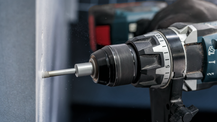 Perceuse rotative faisant un trou dans une surface en verre.