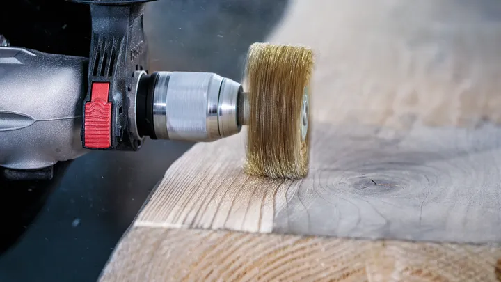 Brosse métallique pour enlever le matériau de surface d'une planche de bois.