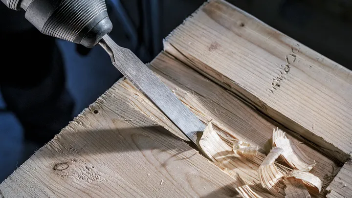 Accessoire ciseau pour retirer les copeaux de bois d'une surface en bois.