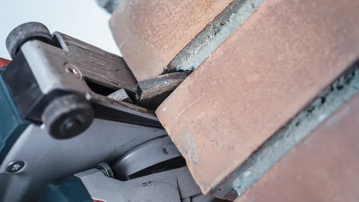 Coupe-dalle en béton réalisant une rainure précise dans une surface en brique.