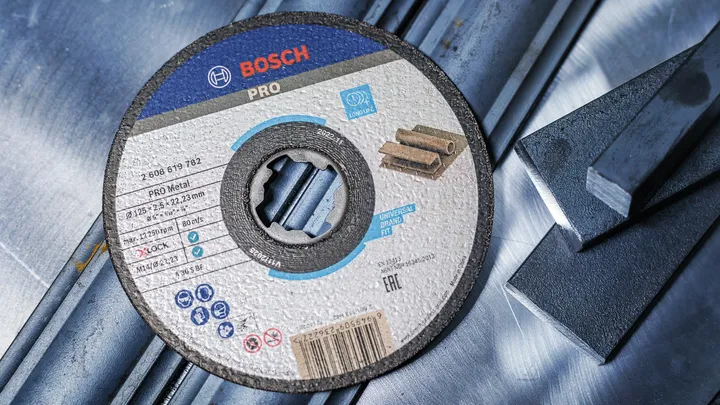 Disque de coupe pour métal reposant sur des barres d'acier.