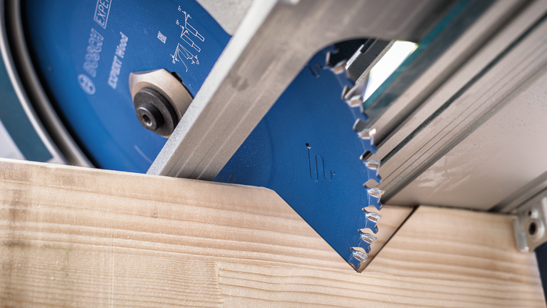 Lame de scie circulaire coupant une planche de bois.