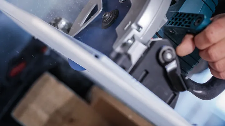 Personne utilisant une scie circulaire pour couper une planche.