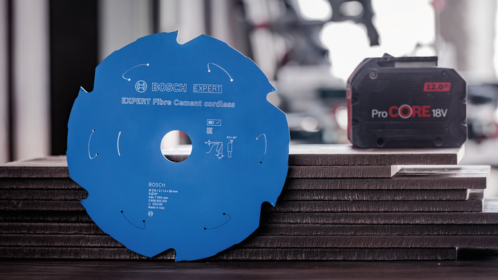 Accessoire d'outil électrique et bloc-batterie placés sur des carreaux empilés.