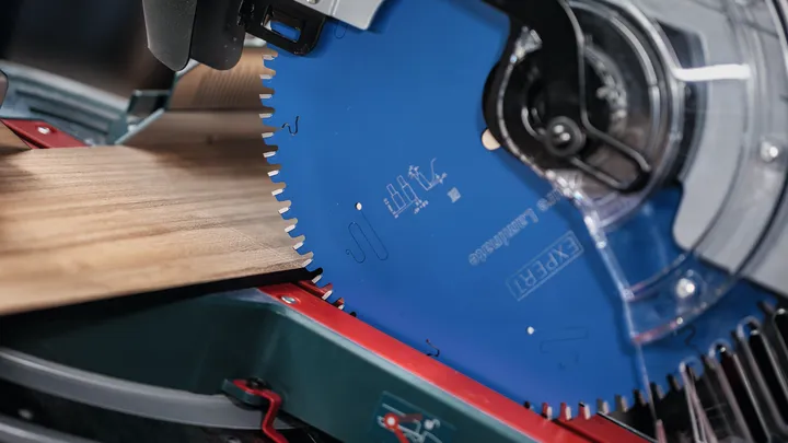 Lame de scie circulaire coupant une planche de bois.