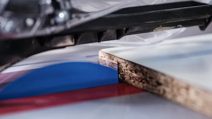 Lame de scie circulaire coupant une planche de bois stratifié.