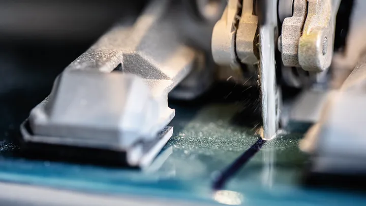 Scie sauteuse coupant une ligne droite à travers une feuille de verre.