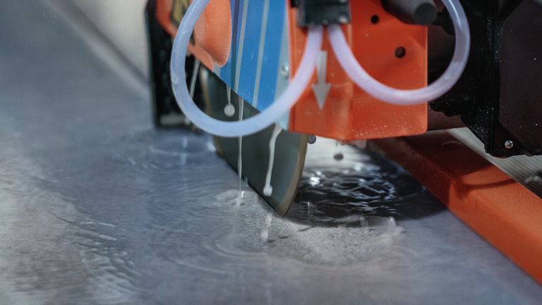 Une lame de scie à eau coupe la pierre tandis que l'eau refroidit la surface.