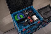 Système de rangement pour outils, bobines de fil et séparateur, installé sur un sol carrelé.