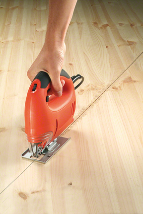 Seghetto alternativo portatile che taglia una linea curva attraverso una tavola di legno.