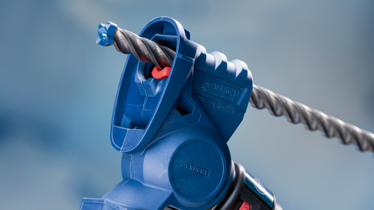 Primo piano di un utensile elettrico blu con una punta da trapano per muratura.
