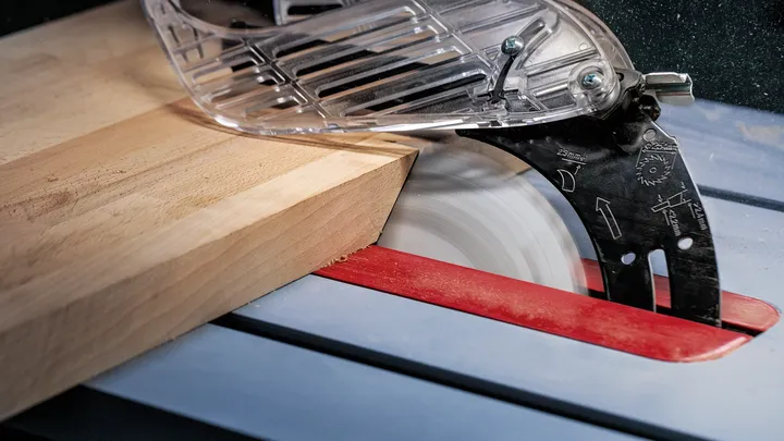 Sega circolare che taglia un pezzo di legno spesso su un tavolo.