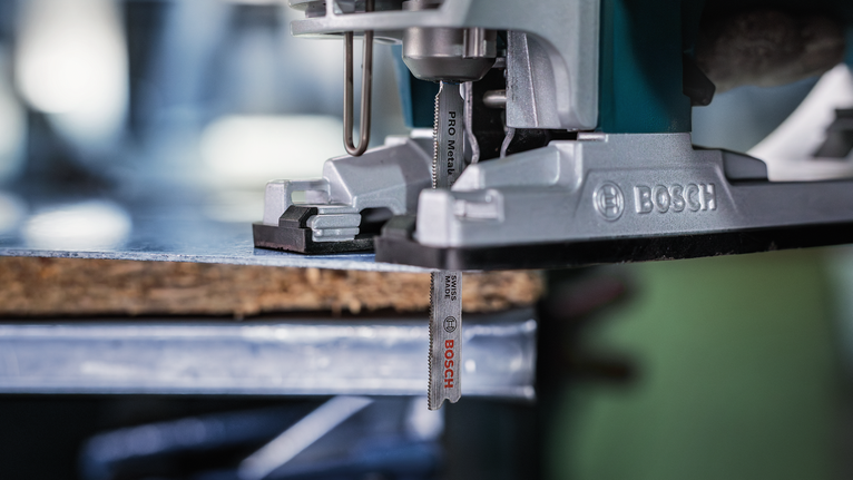 Un seghetto alternativo taglia un pezzo di legno su un banco da lavoro.