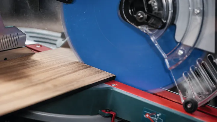 Lama di sega circolare che taglia un pezzo di legno su un banco da lavoro.