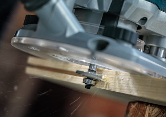 Una fresatrice per legno realizza una scanalatura in una tavola di legno.