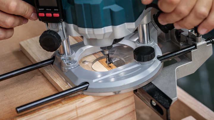 Una persona guida una fresatrice verticale lungo il legno per realizzare scanalature precise.